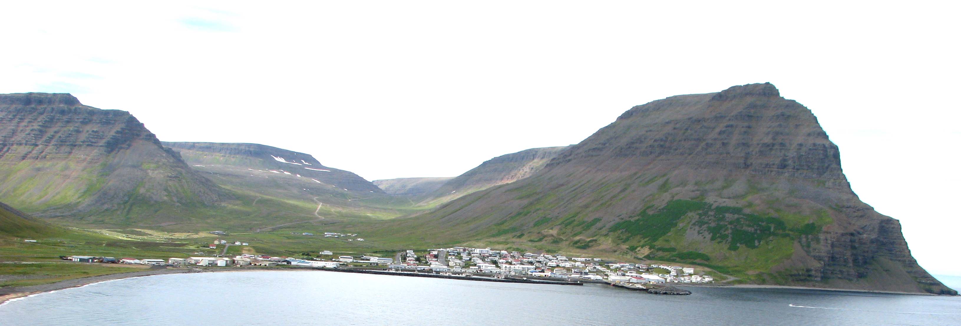 Bolungarvík séð úr Ósvör í júlí 2016. Lengst til vinstri er fjallið Tunguhorn, sem skilur milli Tungudals og Hlíðardals. Fyrir miðri mynd er Lambamúli fyrir botni Hlíðardals en hægra megin gnæfir Traðarhyrna framan í Flatafjalli – Bolafjall fjær – yfir Stigahlíð sjávarmegin. Fram úr Hlíðardal að norðanverðu (hægra megin) liggur vegurinn út í Skálavík um Heiðarskarð. Úr Tungudal (lengst til vinstri) og Syðridal (enn lengra til vinstri og sést ekki á myndinni) eru gönguleiðir yfir í Skutulsfjörð, Hnífsdal og Súgandafjörð.